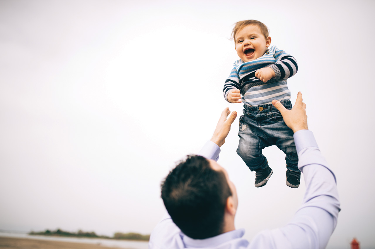 Padre che gioca con figlio lanciandolo in aria