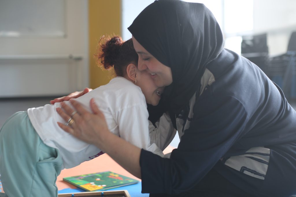 Una mamma e una bimba si abbracciano