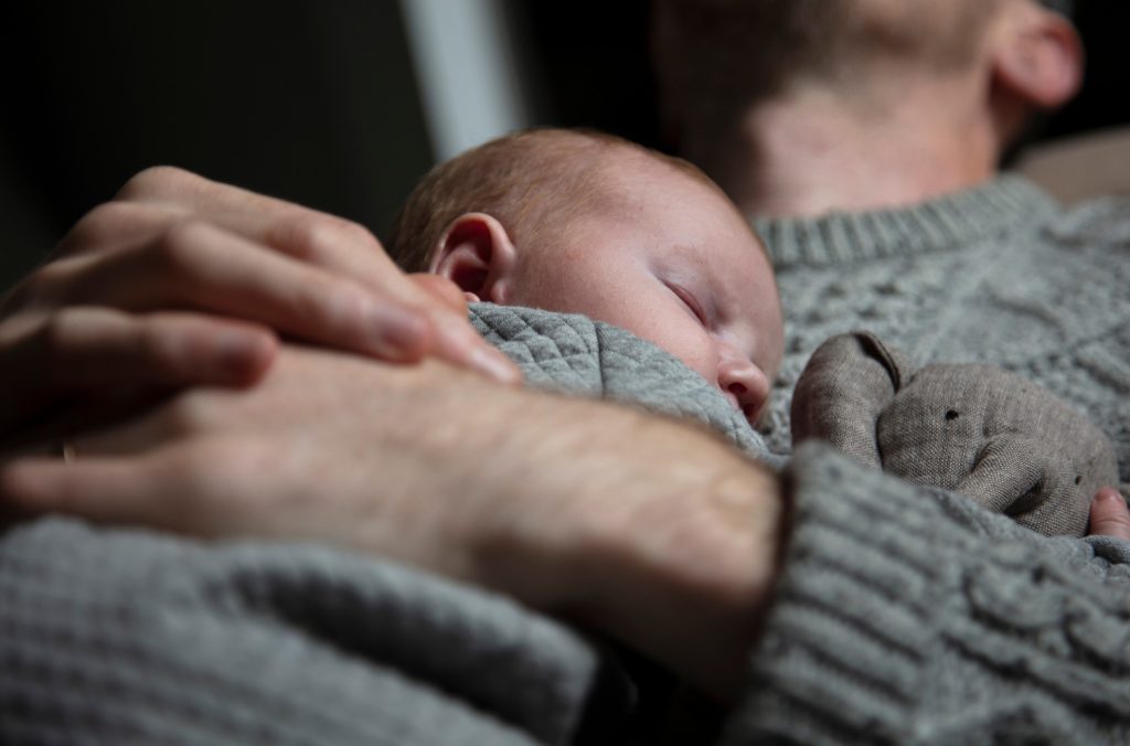 Un papà coccola il suo bimbo neonato