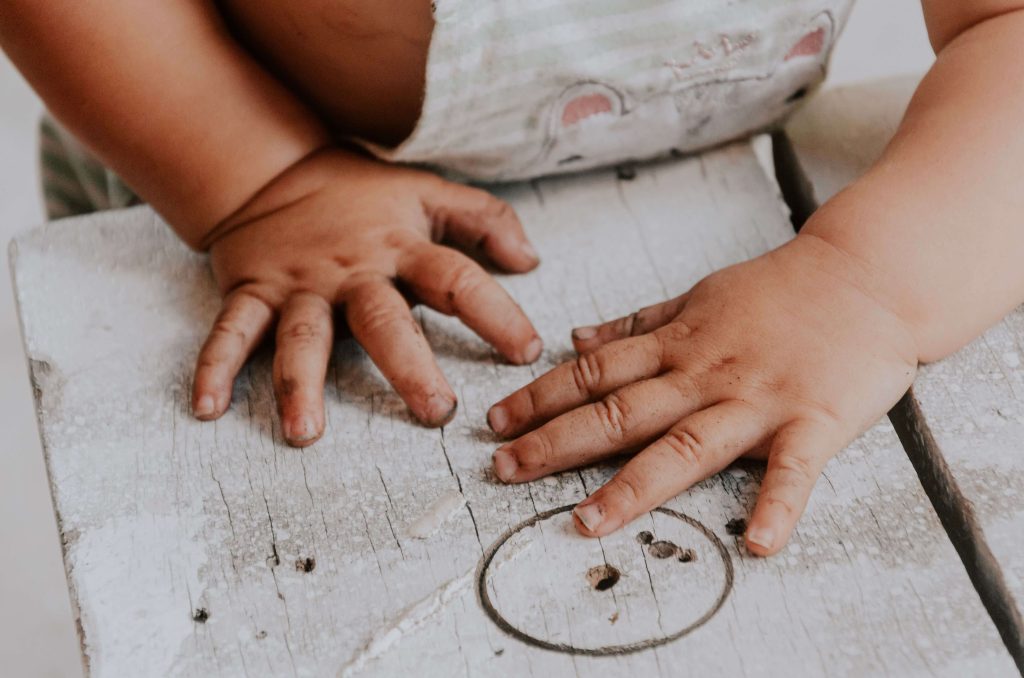 mani sporche di terra di un bambino o una bambina 
