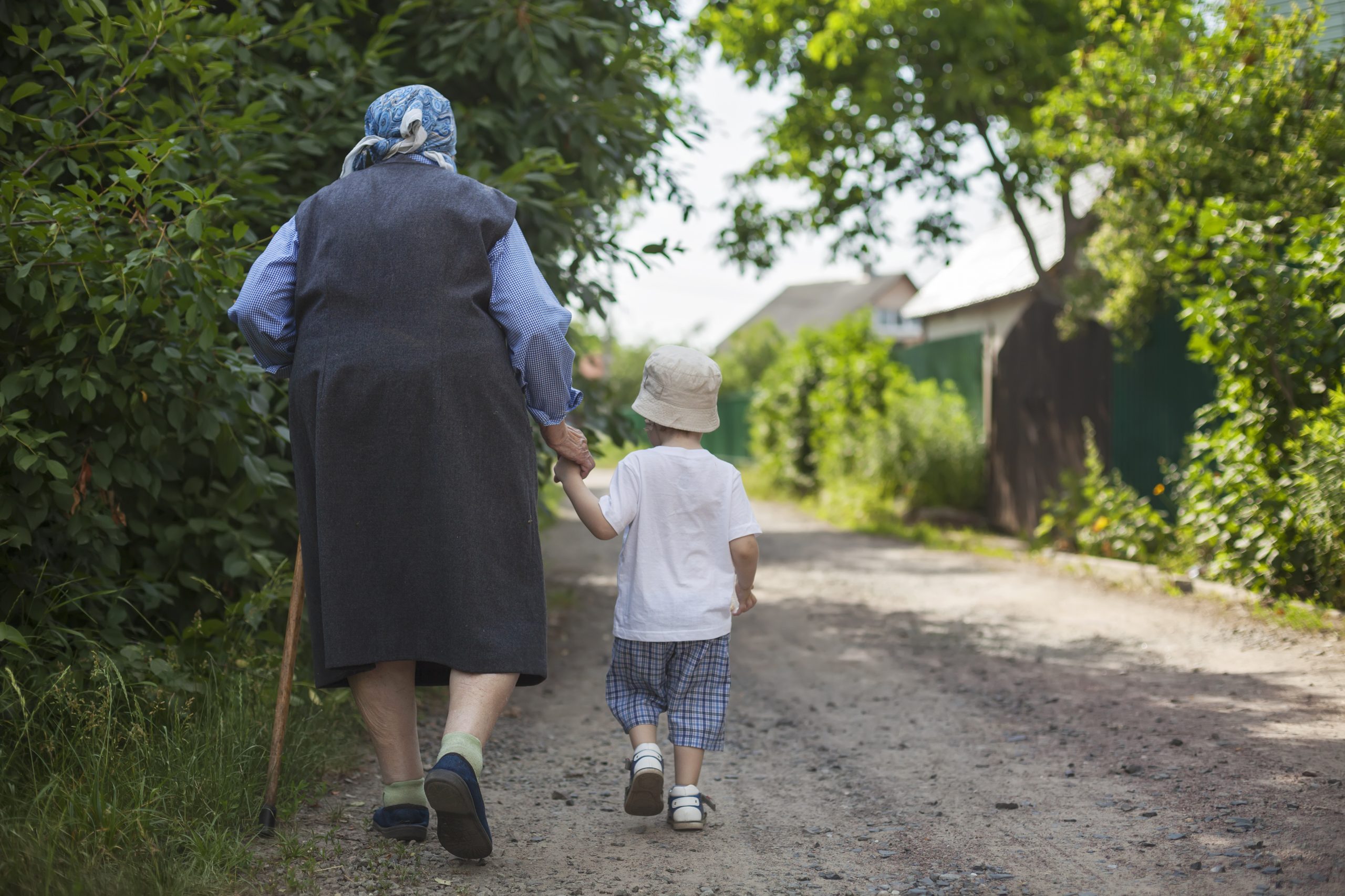 Una nonna e un bambino camminano mano nella mano lungo una strada di campagna, un'immagine del ruolo dei nonni nella crescita
